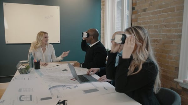 People sitting around a table using VR headsets