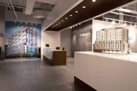 A traditional condo sales centre modern style lobby with white counters and floors