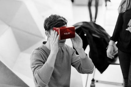 Man holding cardboard Yulio branded headset