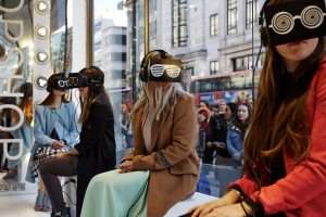 VR for Retail experience at topshop where 4 young women sitting in front of a large store window are wearing VR headsets.