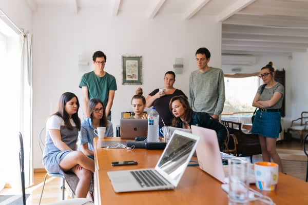 Young adults looking at a computer on a desk