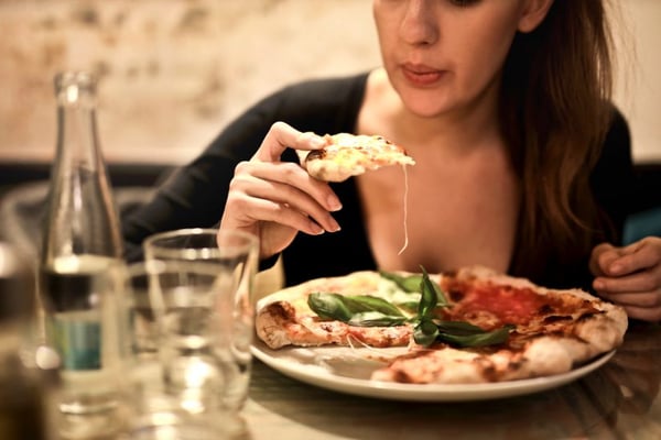 Woman eating pizza in a restaurant